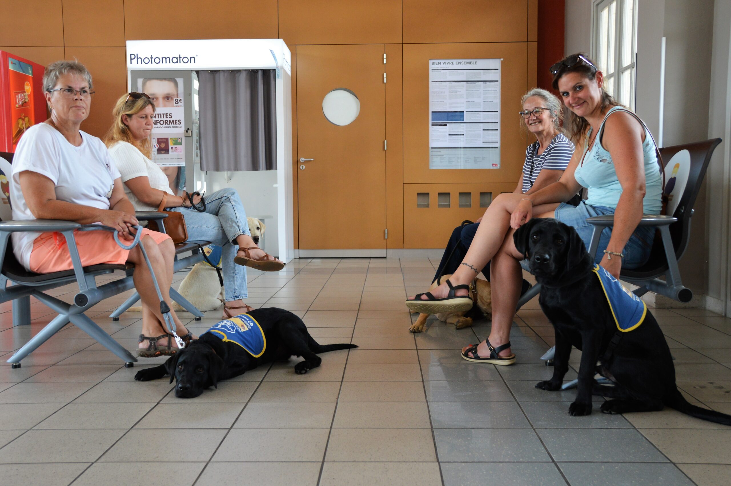 10 ans en Normandie - des familles d'accueil et leur élève chien guide assis dans une salle d'attente à la gare